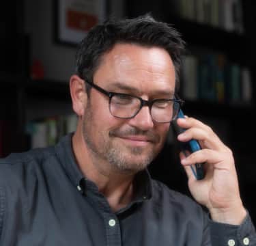 Man wearing a shirt talking over phone