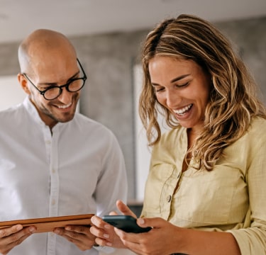 Two people looking at phone and smiling