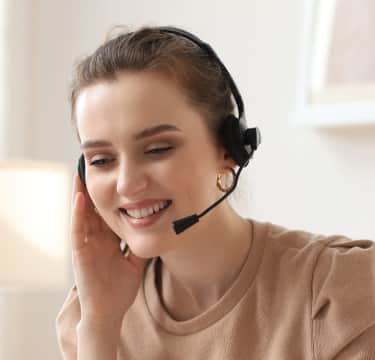 Smiling virtual receptionist touching headset